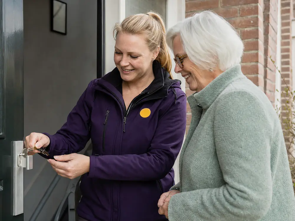 Slotenmaker legt een bewoonster uit hoe haar nieuwe sleutels werken